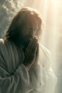 Peaceful bearded figure in flowing white robes with eyes closed in prayer, hands clasped, surrounded by radiant golden light and soft heavenly clouds. Represents faith, devotion, hope, divinity.
