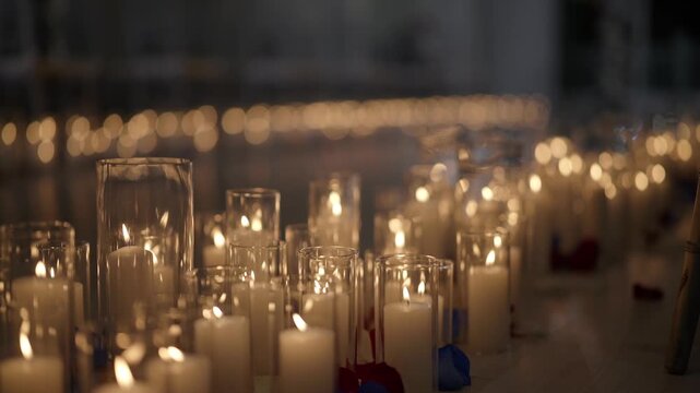 Elegant arrangement of glowing candles in glass cylinders for a romantic evening event setting