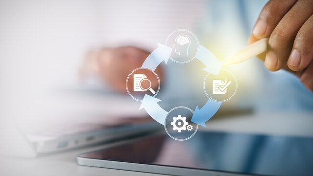 Businessman using stylus pen touching circular workflow process diagram with digital icons on white desk, concept of business management, strategy, automation, and operational efficiency.
