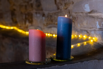 Candles lit in a dimly lit space with decorative lights in the background © funkenzauber