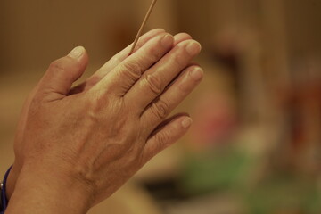 Obraz premium Person holding joss sticks praying