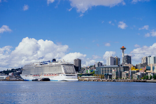 Cruise ship docked at Seattle waterfront with city skyline and space