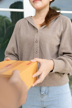 Happy smiling woman receives boxes parcel from courier in front house. Delivery man send deliver express. online shopping, paper containers, takeaway, postman, delivery service, packages