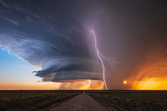 Supercell storm with Lightning over road at sunset in new mexico