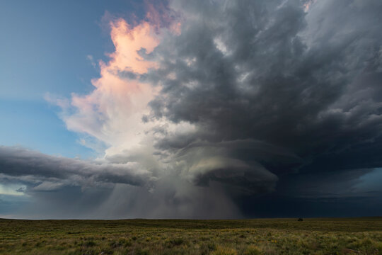 Supercell thunderstorm with rain over grassland