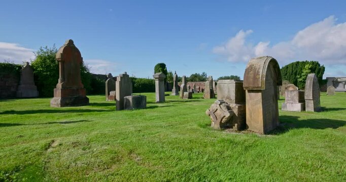 Gimbal walking through old graves in Scottish coastal town's cemetery 2