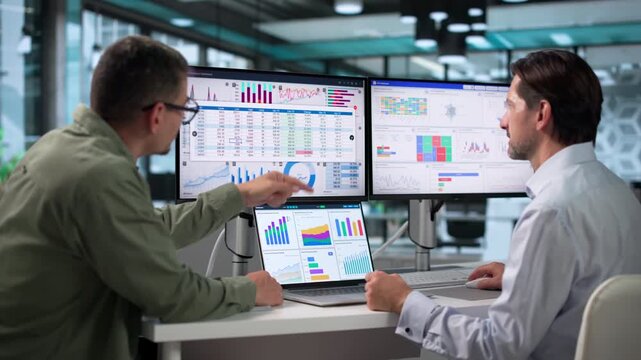 Data Analysts Discussing Financial Dashboard Insights During A Busy Office