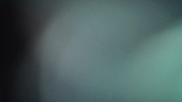 light leak transition with soft grey and teal hues. Perfect for title sequences or scene changes.