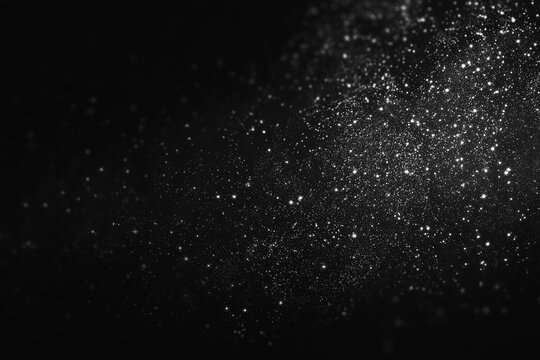 Silver glitter particles on a dark background. Christmas Abstract monochrome shimmering dust texture with bokeh. Galaxy or magical shimmering dust.