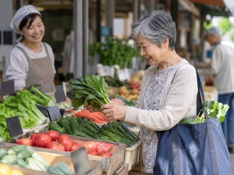 Older woman choosing fresh leafy vegetables at a local market