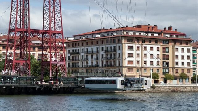 Название: Gondola of the Vizcaya transporter bridge crossing the estuary and docking at the far bank. 