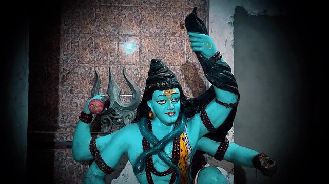 Lord Shiva, or Mahadev, portrayed in a dynamic blessing pose with his raised arm and traditional divine attributes. The blue-toned figure, matted hair, trident.