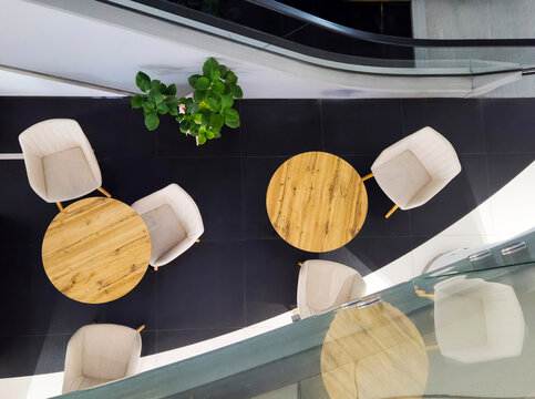 Top view lounge area tables chairs modern interior mall office escalator design furniture aerial minimalist