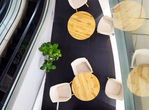 Top view lounge area tables chairs modern interior mall office escalator design furniture aerial minimalist
