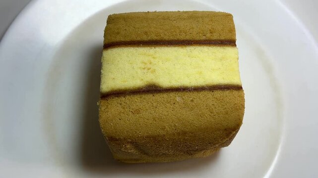 Top view video of Lapis Surabaya, Indonesian layer cake Spiku with jam filling on white plate.