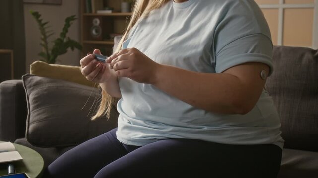 Young adult Caucasian woman injecting insulin into belly using medical pen injector while managing diabetes at home. Footage ideal for pharmaceutical ads and diabetes healthcare campaigns