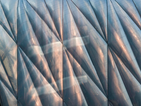 Close-up view of a translucent building facade composed of inflated cushion-like panels divided by triangular seam lines. 
