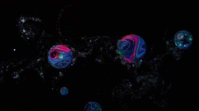 From abstract cosmic dust, droplets resembling planets are formed.