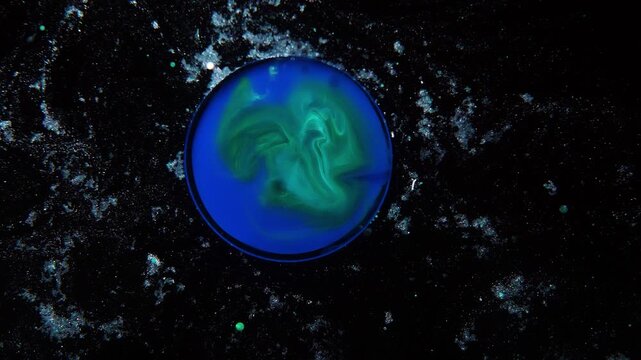 An abstract green‑blue droplet resembling Earth or a habitable planet in the starry cosmos.