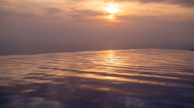 Sunset reflected on calm water surface, minimalist seascape at golden hour