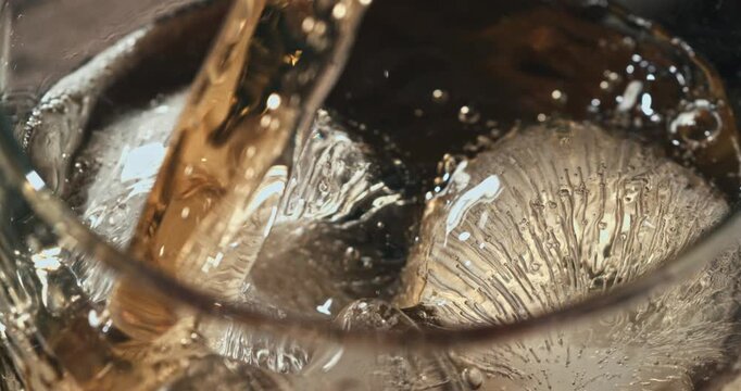 Premium distilled spirit poured over a perfectly round ice cube at 1000 fps, revealing fluid swirls, sparkling reflections and rich amber tones in a sophisticated cinematic close-up.
