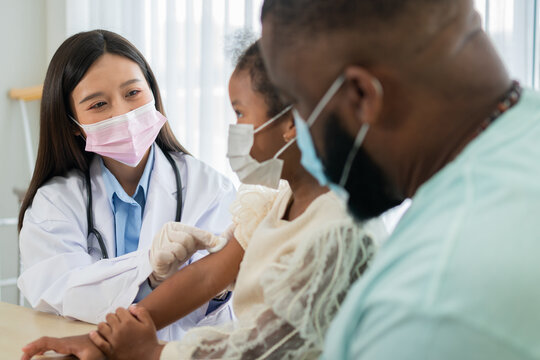 Healthcare professional examining a child during a pediatric medical visit with a parent nearby, representing family healthcare, preventive care, and professional medical support
