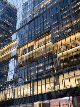 Low-angle view of a business office building at Hudson Yards in Midtown Manhattan at dusk.
