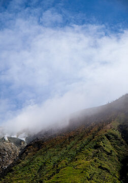 Dramatic landscape of a foggy Mount Talang with lush green slopes in West Sumatera, Indonesia