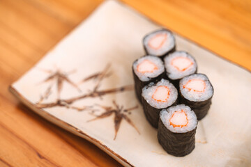 Six pieces of crab stick maki sushi on a decorative plate. © bonnontawat