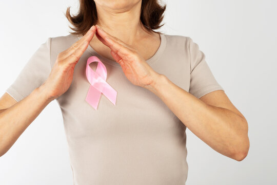 Caucasian Middle Age Woman Framing Pink Ribbon for Breast Cancer Awareness in Studio