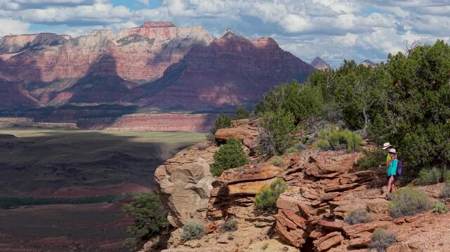 Aerial view of senior couple enjoying hiking on Gooseberry Mesa, taking in views of Zion National Park and surrounding landscape in Utah.