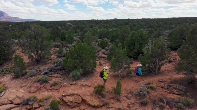 Aerial view of senior couple exploring Gooseberry Mesa in Utah while enjoying views of Zion National Park during their hike.