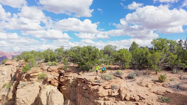 Aerial view of senior couple hiking across Gooseberry Mesa in Utah, enjoying views of Zion National Park and surrounding landscapes.