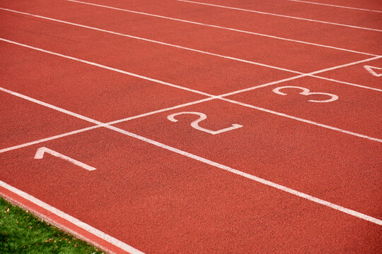 Empty red running track with numbered lanes