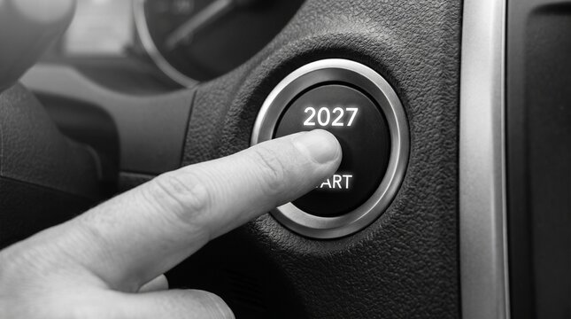 Finger pressing a car start button with 2027 concept representing future business growth