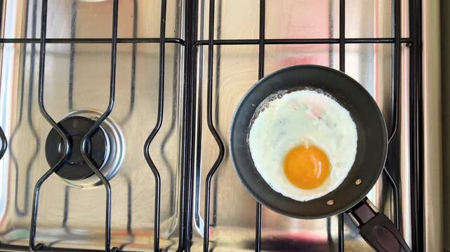 Fried egg sizzling in pan during cooking