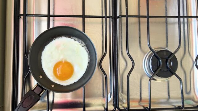 Close up of fried egg cooking in a frying pan