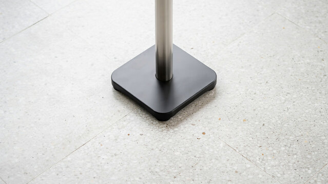 Black square base of a pole on a tiled floor