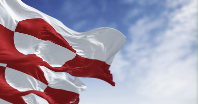 Flags of Greenland waving in the wind on a clear day.