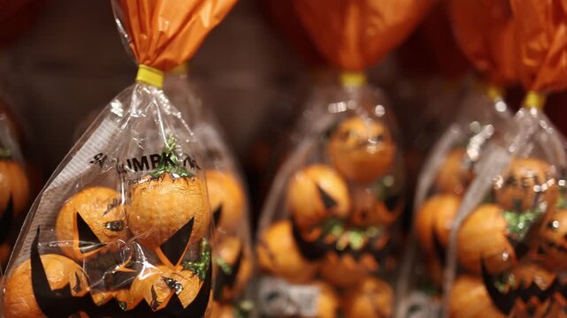 Halloween pumpkin chocolates wrapped as tiny jack o lanterns fill festive treat bags bringing playful spooky style to trick or treat parties and seasonal celebrations
