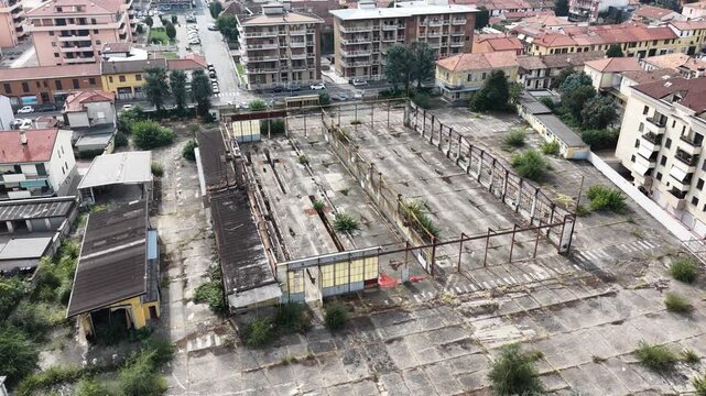 Aerial view of abandoned urban infrastructure surrounded by residential buildings in northern Italy