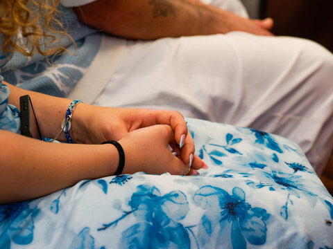 Mains d&rsquo;une invit&eacute;e pos&eacute;es sur ses genoux pendant une c&eacute;r&eacute;monie de mariage civil