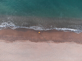 Lonely man relaxing on the beautiful beach at sunset. Sun reflected on beach, Lonely man stands on the beach looks towards the sun light. A man meets the sunset on beach, silhouette of person walking. © Mediterranean sea