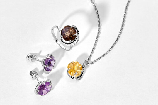 Elegant jewelry set. Jewellery set with gemstones. Product still life concept. Ring, necklace and earrings.
