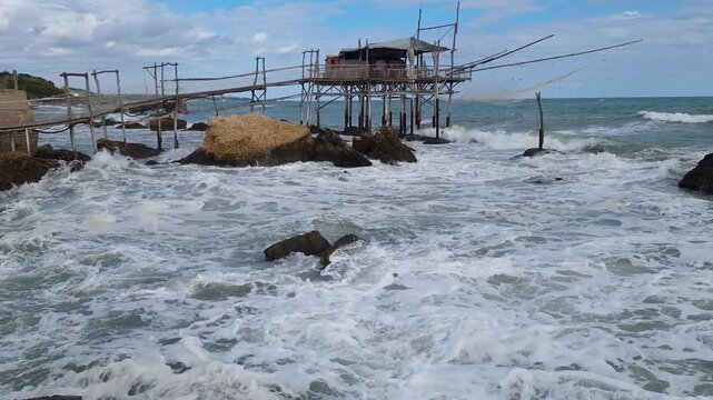 Trabocco seafood restaurant Costa dei Trabocchi San Vito Chietino Abruzzo Italy dining on stilts wooden pier with fishing net, sea view traditional fish venue. sea sounds 4k video