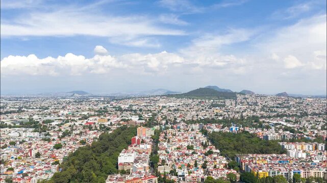 Aerial timelapse of clouds forming over Paseos de Taxque&ntilde;a and Cerro de la Estrella in Coyoacan, Mexico City, Mexico during a sunny day