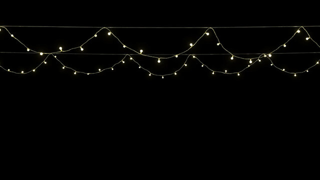 String lights hanging against a black background for festive or decorative use