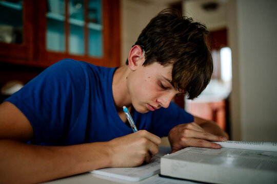 Teen Student with Cochlear Implant Studying and Writing at Home