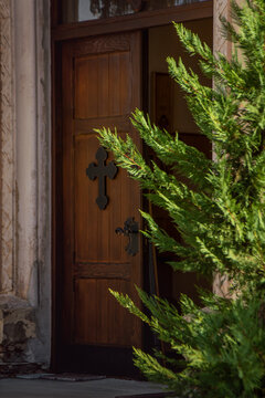 Wooden church door through tree branches