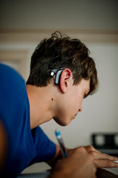 Teen Student with Cochlear Implant Doing Homework at Home